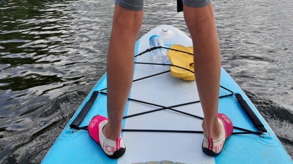 child standing on a paddleboard